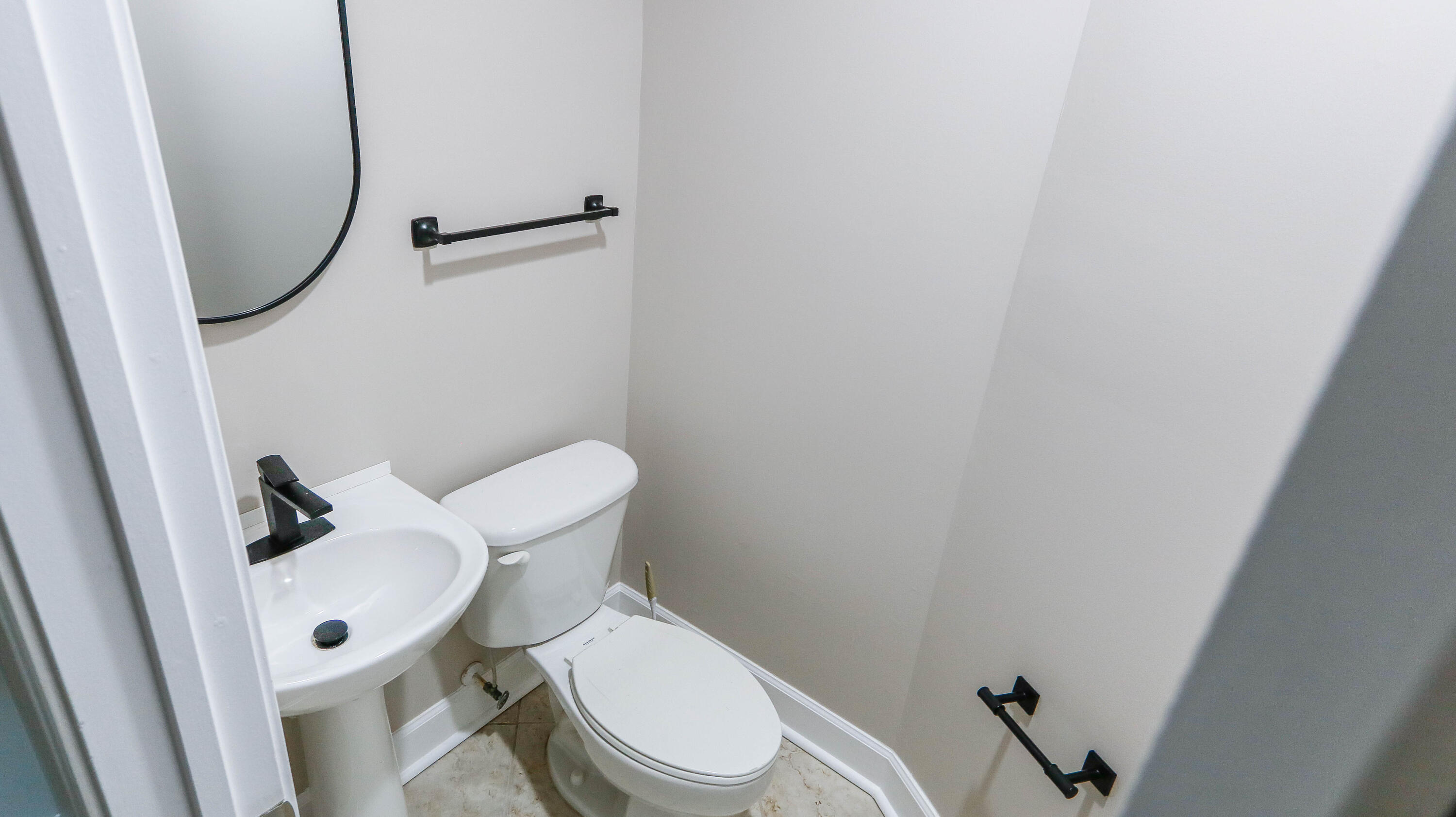 8700 Front Beach Road, Unit 1311 Panama City Beach, FL 32407 - Photo 32 of 65 a white toilet sitting next to a sink and a mirror