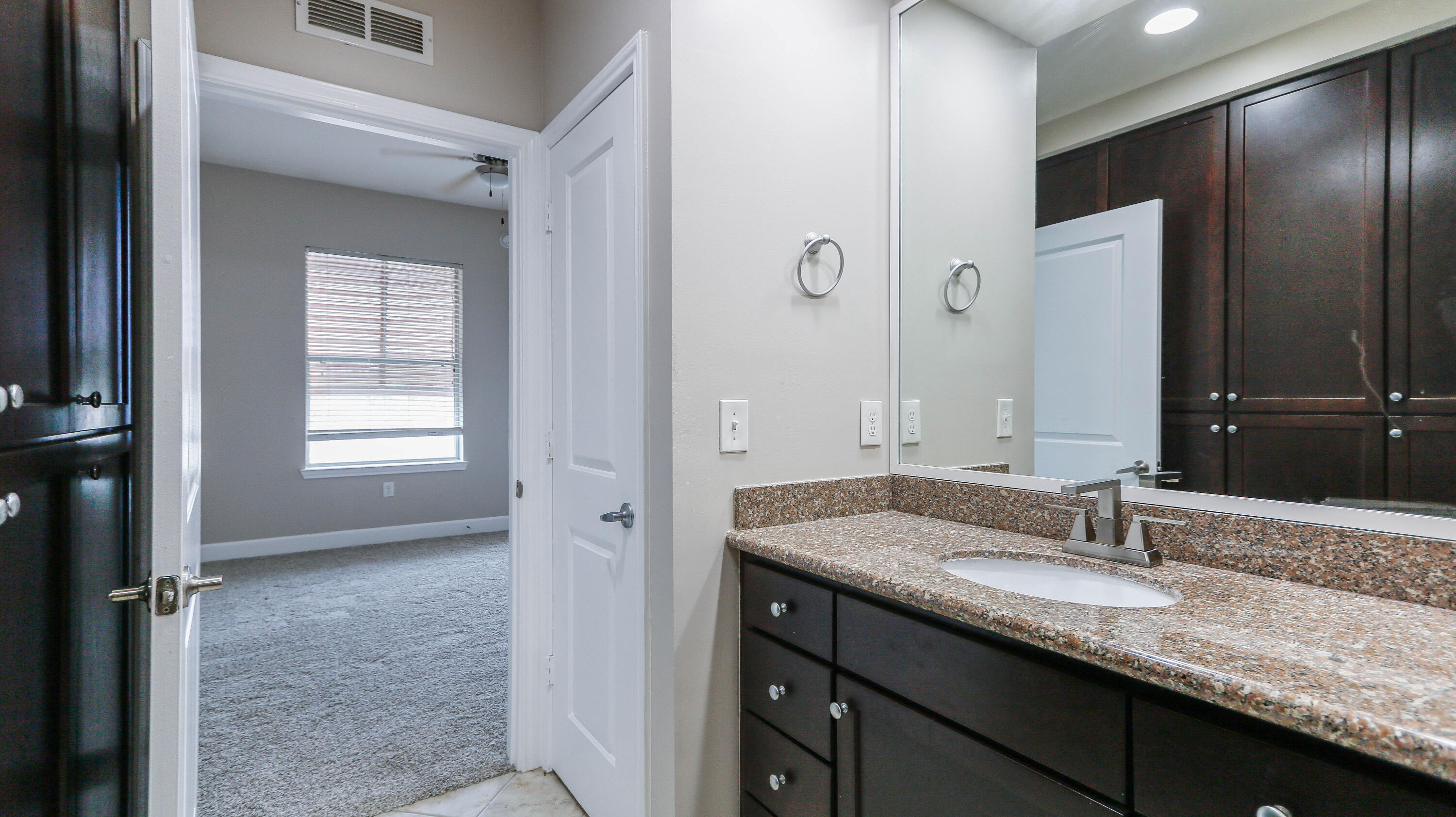 8700 Front Beach Road, Unit 1311 Panama City Beach, FL 32407 - Photo 43 of 65 a bathroom with a granite countertop sink and a mirror