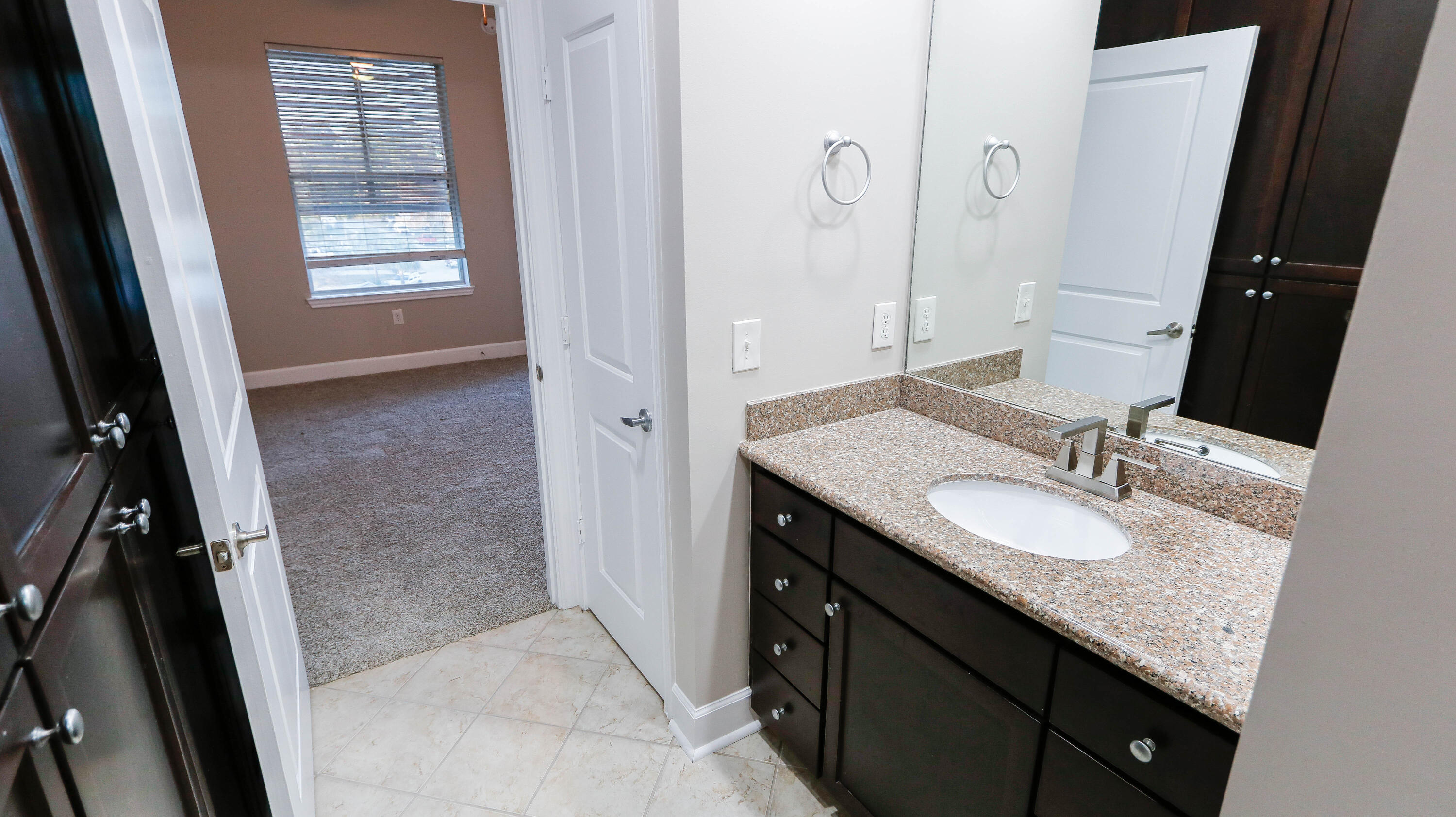 8700 Front Beach Road, Unit 1311 Panama City Beach, FL 32407 - Photo 49 of 65 a bathroom with a granite countertop sink a mirror and a shower