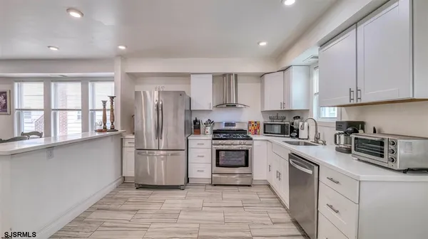 a kitchen with stainless steel appliances granite countertop a refrigerator sink and stove