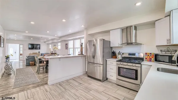a kitchen with stainless steel appliances a refrigerator a stove top oven and sink