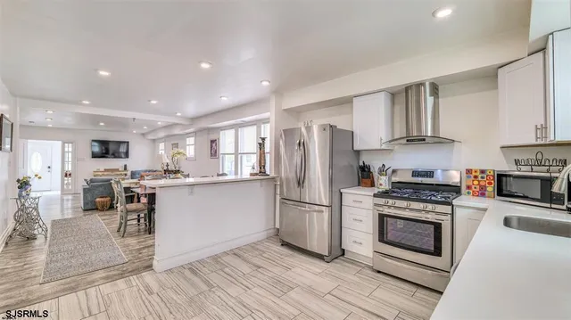a kitchen with stainless steel appliances a refrigerator a stove top oven and sink
