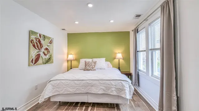 a bedroom with a bed and painting on the wall