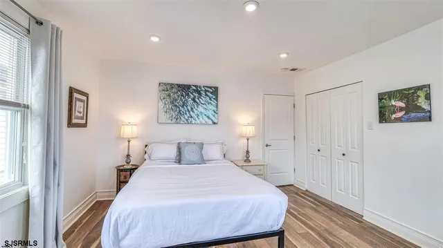 a bedroom with a bed and a painting on the wall