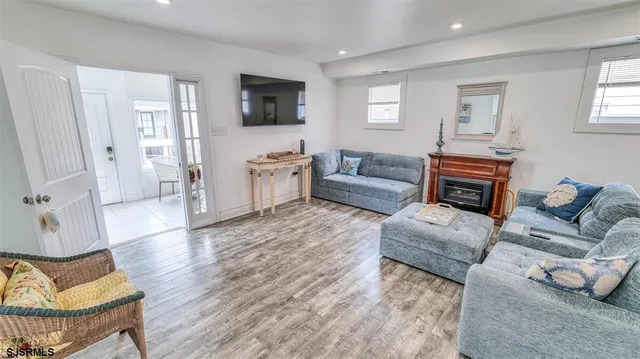 a living room with furniture a flat screen tv and a fireplace