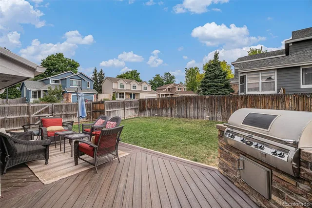 a view of a roof deck with table and chairs with wooden floor and fence