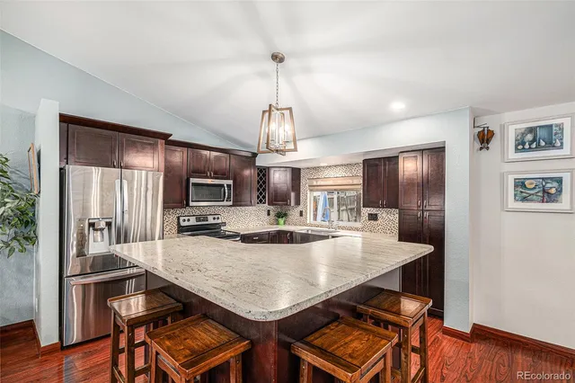 a view of a dining room with furniture a chandelier and wooden floor