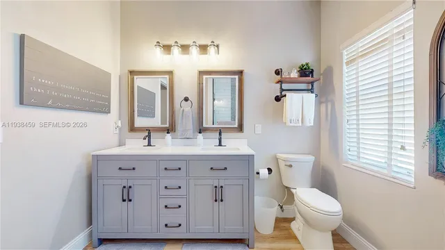 a bathroom with a granite countertop toilet sink and mirror
