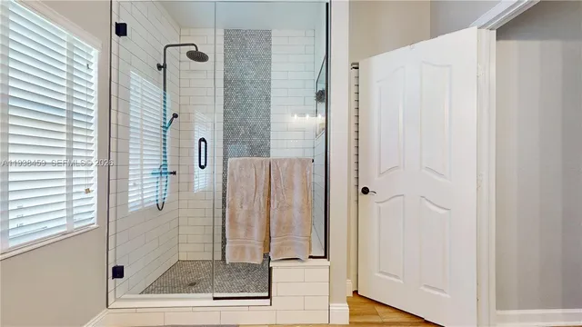 a bathroom with a glass shower door and a glass door