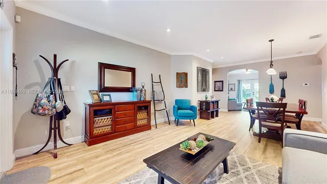 a living room with furniture a wooden floor and a flat screen tv