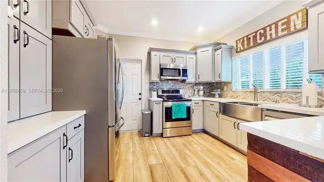 a kitchen with stainless steel appliances a stove a sink and a refrigerator