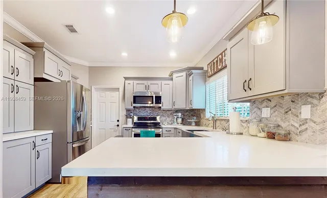 a kitchen with stainless steel appliances a refrigerator sink and white cabinets