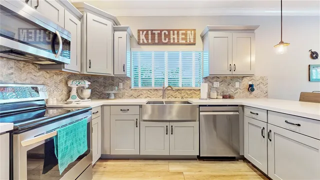 a kitchen with stainless steel appliances granite countertop a sink and cabinets with wooden floor