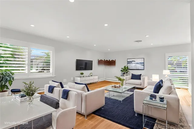a living room with furniture flat screen tv and a large window