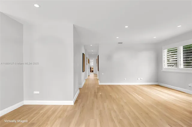 a view of a big room with wooden floor and windows