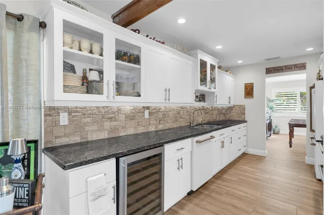 a kitchen with granite countertop a sink and cabinets