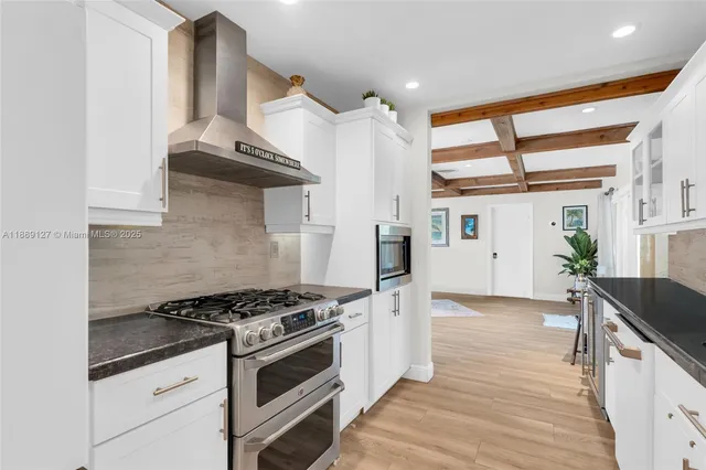 a kitchen with granite countertop a stove and a wooden floors