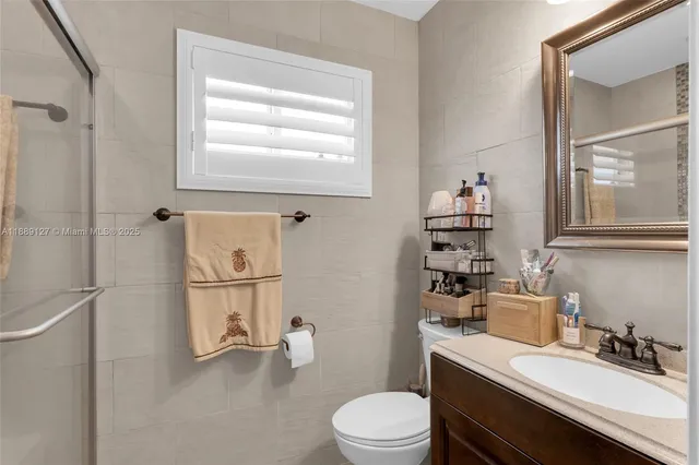 a bathroom with a sink toilet vanity and shower