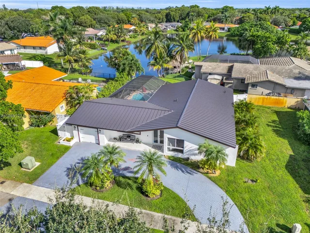 an aerial view of a house with a garden and lake view