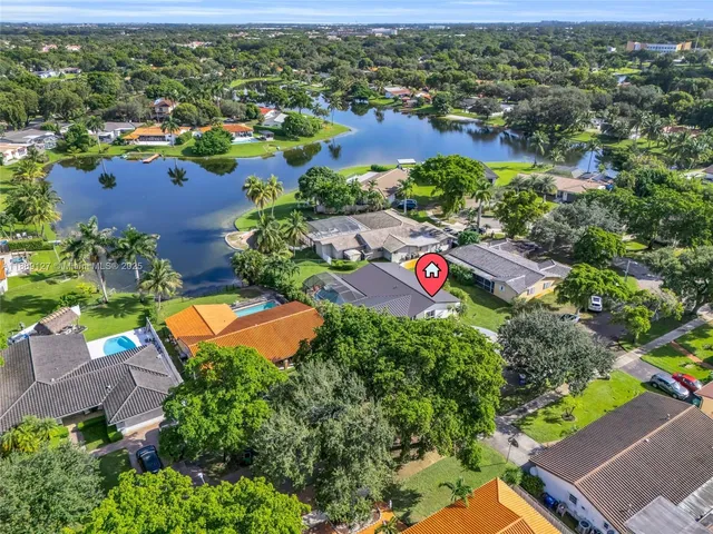 an aerial view of residential houses with outdoor space and trees all around