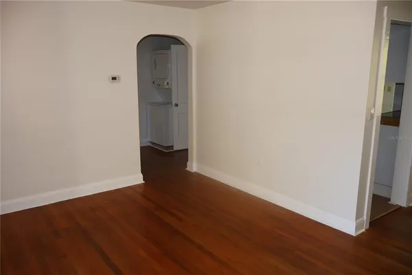 a view of empty room with wooden floor and window