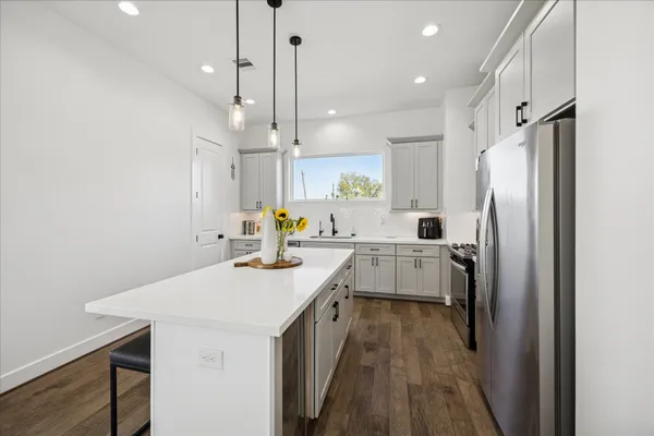 a kitchen with white cabinets and stainless steel appliances