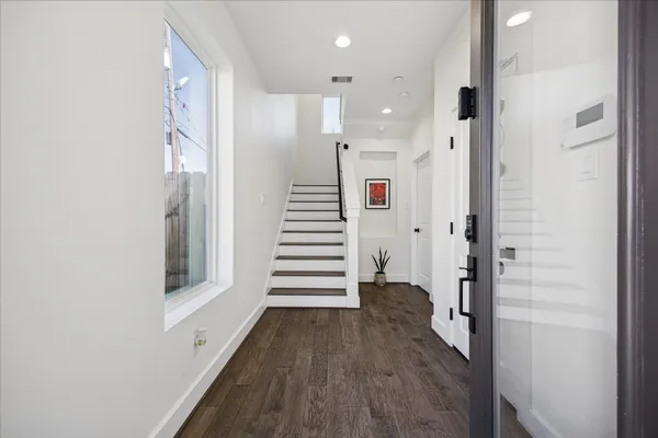 a view of a hallway with wooden floor and staircase