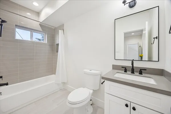 a bathroom with a granite countertop toilet a sink and a bathtub
