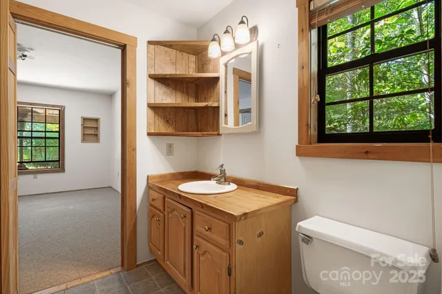 a bathroom with a granite countertop sink and a toilet