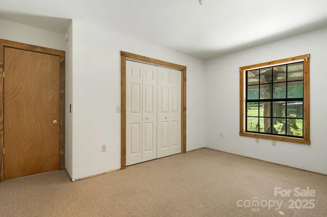 an empty room with windows and closet