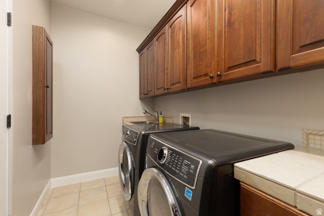1257 West 2320 South St. George, UT 84770 - Photo 15 of 55 Laundry area featuring wood-finish cabinetry, tile flooring, a utility sink, and a countertop