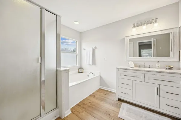 a spacious bathroom with a double vanity sink a mirror and a bathtub