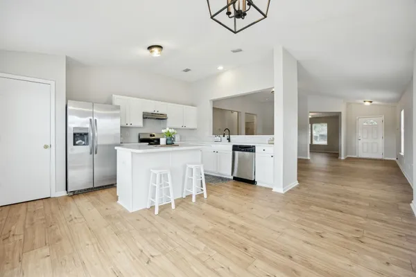 a kitchen with stainless steel appliances a refrigerator sink and cabinets