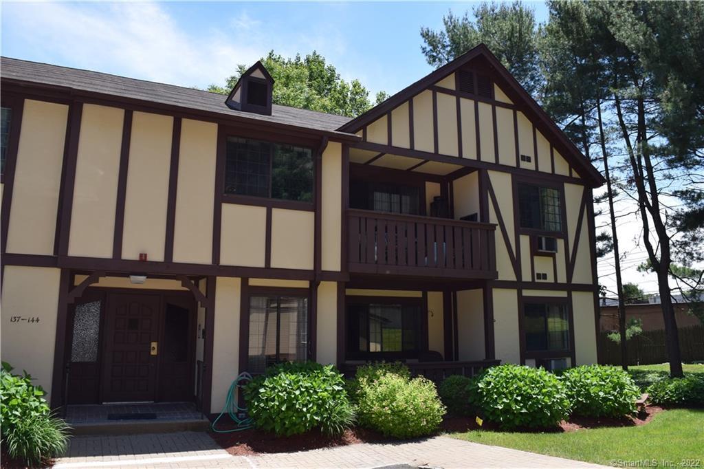 125 Warner Hill Road, Unit 138 Stratford, CT 06614 - Photo 1 of 1 a view of a house with large windows and a flower plants next to a yard
