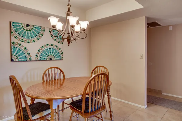 a view of a dining room with furniture a chandelier and wooden floor