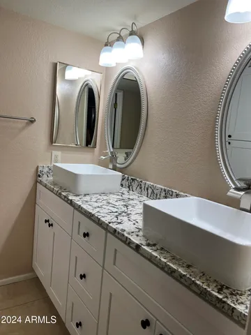 a bathroom with a granite countertop sink and mirror