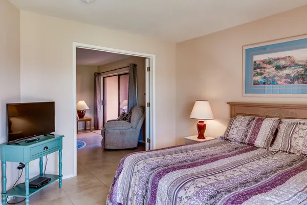 a bedroom with a bed and a flat screen tv