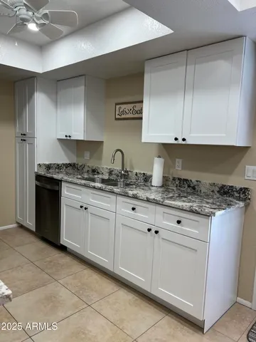 a kitchen with granite countertop a sink stainless steel appliances and cabinets