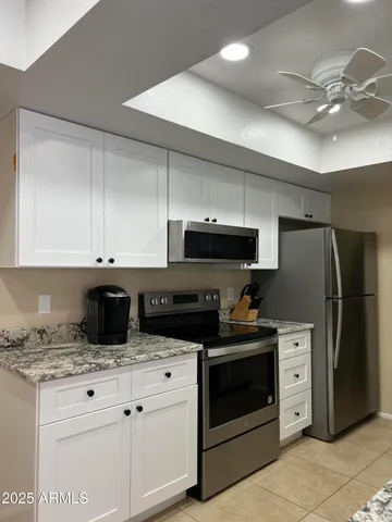 a kitchen with granite countertop a stove sink and refrigerator