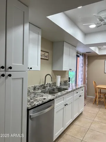 a kitchen with kitchen island granite countertop a sink stainless steel appliances and cabinets