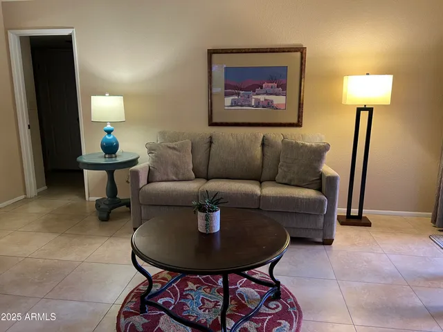 a living room with furniture a lamp and a rug