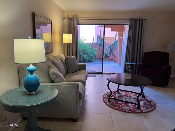 a living room with furniture a lamp and a large window