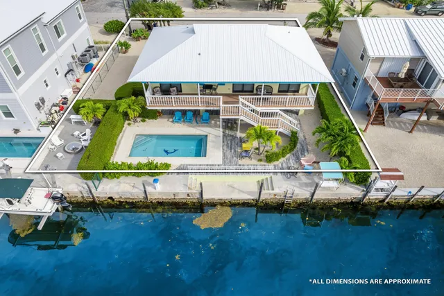 an aerial view of a house with swimming pool lake view and mountain view