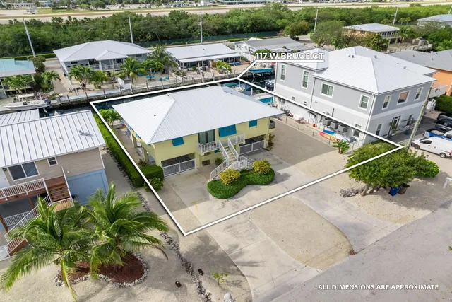 an aerial view of a house with a garden and lake view