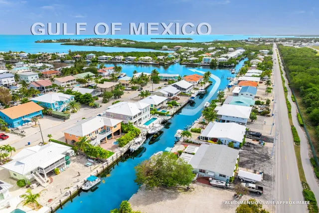 an aerial view of residential houses with outdoor space and swimming pool