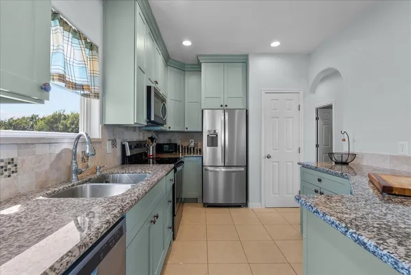 a kitchen with a sink refrigerator and microwave