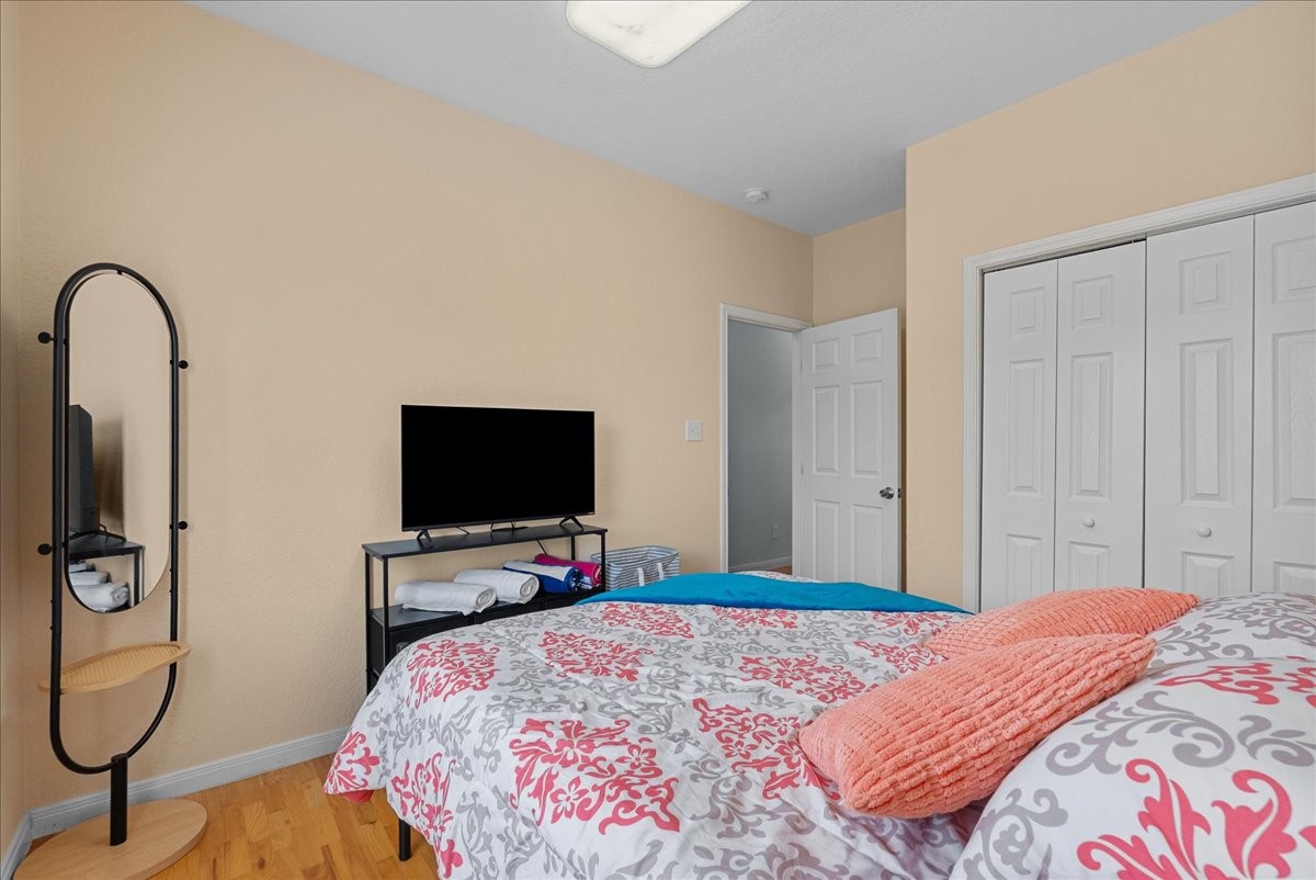 1012D 22nd Street, Unit D Dickinson, TX 77539 - Photo 24 of 44 a bedroom with a bed and a flat tv screen on dresser
