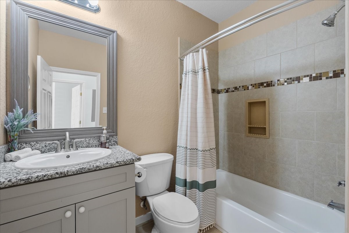 1012D 22nd Street, Unit D Dickinson, TX 77539 - Photo 25 of 44 a bathroom with a granite countertop sink toilet and shower
