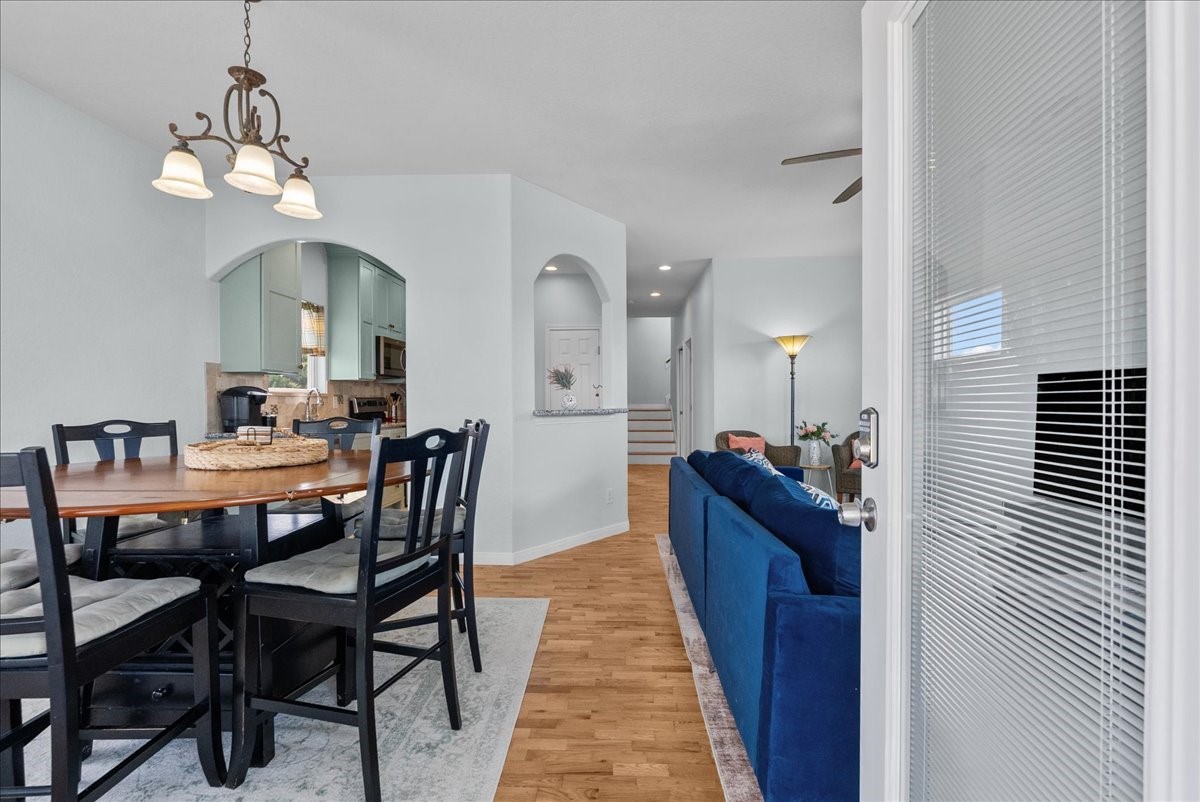 1012D 22nd Street, Unit D Dickinson, TX 77539 - Photo 5 of 44 a dining room with wooden floor a chandelier a wooden table and chairs