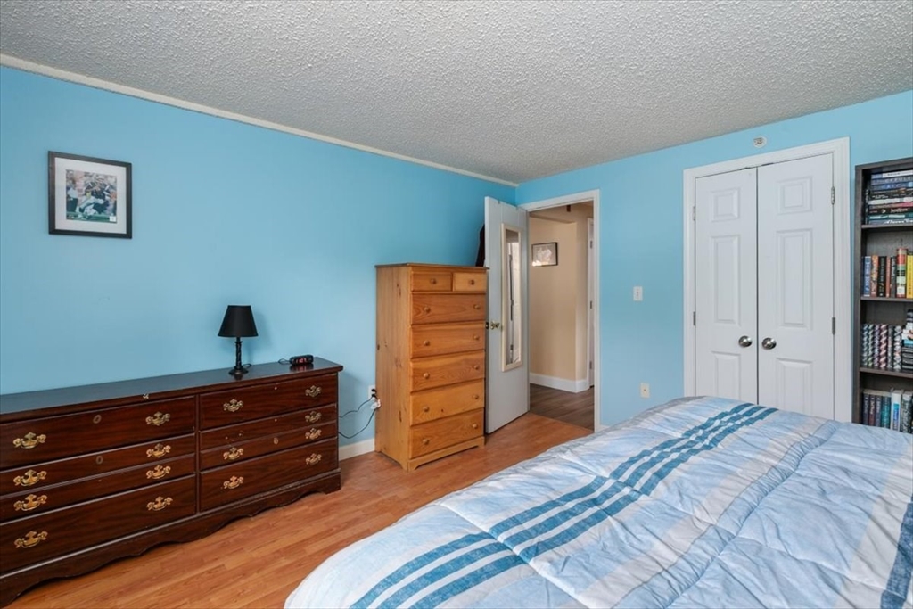 25 Clark's Road, Unit 101 Amesbury, MA 01913 - Photo 15 of 32 a bedroom with a bed and a dresser